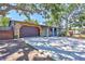 Exterior view of a single story home with attached garage and a spacious driveway with mature trees at 6443 34Th N Ave, St Petersburg, FL 33710