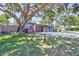 Exterior view of a single story home with attached garage and a spacious front yard with mature trees at 6443 34Th N Ave, St Petersburg, FL 33710