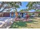 Charming single-story home with stone accents, blue facade, mature trees, and landscaped front yard at 6443 34Th N Ave, St Petersburg, FL 33710