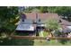 Aerial view of the home showcasing the fenced backyard with artificial turf, covered patio, and screen room at 15515 Morning Dr, Lutz, FL 33559