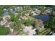 Aerial view of homes in a wooded community with a tranquil pond and scenic surroundings at 15515 Morning Dr, Lutz, FL 33559