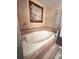 A bathroom features a white soaking tub with tile surround and a handheld shower fixture at 15515 Morning Dr, Lutz, FL 33559