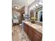 A remodeled bathroom features double sinks, stone accents, new lighting, and a glass shower at 15515 Morning Dr, Lutz, FL 33559
