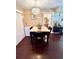Dining area with wood floors features a table with four chairs and contemporary light fixture at 15515 Morning Dr, Lutz, FL 33559