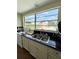Functional kitchen featuring a sink, black countertops, and a large window with a pool view at 15515 Morning Dr, Lutz, FL 33559