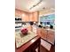 Cozy kitchen features light wood cabinets, speckled granite countertops, and an island with granite top at 15515 Morning Dr, Lutz, FL 33559