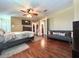 This spacious main bedroom features wood floors, a ceiling fan, a TV, and seating at 15515 Morning Dr, Lutz, FL 33559