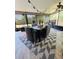 A screened patio features a dining table set on a geometric rug, and overhead decorative lighting at 15515 Morning Dr, Lutz, FL 33559