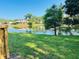 Scenic pond view with lush green lawn and mature trees creating a serene outdoor setting at 15515 Morning Dr, Lutz, FL 33559