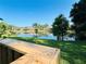 Scenic pond view with lush green lawn and mature trees creating a serene outdoor setting at 15515 Morning Dr, Lutz, FL 33559