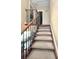 A view of the carpeted staircase with dark wood and wrought iron spindles ascending to the next level at 15515 Morning Dr, Lutz, FL 33559