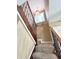 The carpeted staircase with a dark wood and iron railing features a window and overhead lighting at 15515 Morning Dr, Lutz, FL 33559