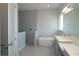 Modern bathroom featuring a standalone tub, glass-enclosed shower, and dual vanities with quartz countertops at 9544 Brave Buck Ave, Land O Lakes, FL 34638