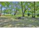 Large backyard with mature trees and a fire pit offering a serene outdoor space for relaxation and entertainment at 13091 Old Crystal River Rd, Brooksville, FL 34601