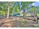 Large backyard featuring mature trees, chicken coop, storage shed, and a classic blue pickup truck at 13091 Old Crystal River Rd, Brooksville, FL 34601