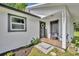 Inviting front porch with seating, a welcome wreath, and lovely landscaping at 13091 Old Crystal River Rd, Brooksville, FL 34601
