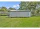 Outbuilding with white siding, a single door, and set on a grassy lawn at 13091 Old Crystal River Rd, Brooksville, FL 34601