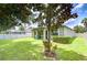 Scenic backyard view highlighting mature landscaping, a covered patio, and ample green space for recreation at 107 Dakota Hill Dr, Seffner, FL 33584