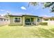 Inviting backyard with covered patio, chairs, grill, and a well-manicured lawn at 107 Dakota Hill Dr, Seffner, FL 33584