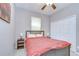 Bedroom featuring a dark-colored bed frame, red comforter, bedside tables, and minimalist decor at 107 Dakota Hill Dr, Seffner, FL 33584