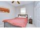 Traditional bedroom with a dark-colored bed frame, red comforter, bedside tables, and minimalist decor at 107 Dakota Hill Dr, Seffner, FL 33584