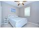 Bedroom featuring a white bed frame, light-colored walls, a ceiling fan, and a bright window at 107 Dakota Hill Dr, Seffner, FL 33584