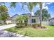 Beautifully landscaped front yard features palm trees, green grass, and tidy shrubbery at 107 Dakota Hill Dr, Seffner, FL 33584