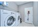 Bright laundry room with white washer and dryer units, and shelving for storage at 107 Dakota Hill Dr, Seffner, FL 33584