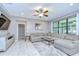 Bright living room with tile floors, neutral walls, a ceiling fan, and a large gray sectional sofa at 107 Dakota Hill Dr, Seffner, FL 33584