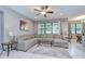 Open concept living room with large sectional sofa, neutral decor, and view of dining area and backyard at 107 Dakota Hill Dr, Seffner, FL 33584
