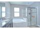 Bright bathroom featuring double vanity with granite counters, soaking tub, and glass shower enclosure at 107 Dakota Hill Dr, Seffner, FL 33584
