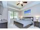 The main bedroom features a tray ceiling, dark wood furnishings, and a large window overlooking the backyard at 107 Dakota Hill Dr, Seffner, FL 33584