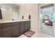 Modern bathroom features dual sinks, granite countertops, dark cabinetry and purple accents at 13797 Wineberry Dr, Dade City, FL 33525
