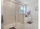 Bathroom featuring glass enclosed shower and tub, with neutral tile and modern fixtures at 13797 Wineberry Dr, Dade City, FL 33525