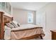 Cozy bedroom boasts a comfortable bed with neutral bedding and a window with blinds at 13797 Wineberry Dr, Dade City, FL 33525
