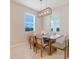 Bright dining room with modern chandelier, table and chairs, and natural light from nearby windows at 13797 Wineberry Dr, Dade City, FL 33525