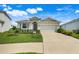Charming single-story home featuring manicured lawn, neutral stucco, and a two-car garage at 13797 Wineberry Dr, Dade City, FL 33525