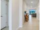 Bright hallway featuring tile flooring, neutral walls and decor leading into a living area with outside view at 13797 Wineberry Dr, Dade City, FL 33525