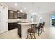 Modern kitchen features a large island with seating, granite countertops, and stainless steel appliances at 13797 Wineberry Dr, Dade City, FL 33525