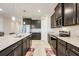 Well-equipped kitchen with stainless steel appliances, granite countertops, dark cabinetry, and ample counter space at 13797 Wineberry Dr, Dade City, FL 33525