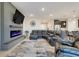 Open-concept living room features a sectional sofa, modern fireplace with TV, and open flow to the kitchen at 13797 Wineberry Dr, Dade City, FL 33525