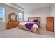 Well-lit main bedroom boasts tray ceilings, wood furniture and plush bedding at 13797 Wineberry Dr, Dade City, FL 33525
