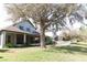 Expansive backyard with lush lawn, mature trees, a screened porch, and charming swing, perfect for relaxation at 26620 Shoregrass Dr, Wesley Chapel, FL 33544