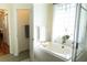 Bright bathroom featuring a glass enclosed walk-in shower, soaking tub, and tiled window at 26620 Shoregrass Dr, Wesley Chapel, FL 33544