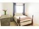 Bedroom featuring a full bed with side table, a dresser, and a large bright window at 26620 Shoregrass Dr, Wesley Chapel, FL 33544