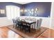 A dining room features a blue accent wall, a chandelier, and a table set on a patterned rug at 26620 Shoregrass Dr, Wesley Chapel, FL 33544