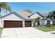 A charming single-story home featuring a three-car garage and a neatly manicured lawn at 26620 Shoregrass Dr, Wesley Chapel, FL 33544