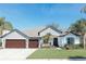Charming single-story home featuring a three-car garage, beautiful landscaping, and a well-maintained lawn at 26620 Shoregrass Dr, Wesley Chapel, FL 33544