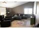 A cozy living room features a comfortable sectional couch and large bright window at 26620 Shoregrass Dr, Wesley Chapel, FL 33544