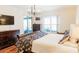 Bright and airy primary bedroom with hardwood floors, large window, and a modern light fixture at 26620 Shoregrass Dr, Wesley Chapel, FL 33544